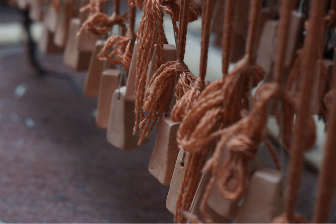 Close-up of terracotta weights knotted to groups of woollen threads.
