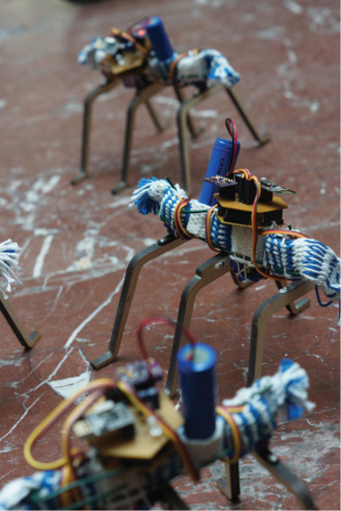 Small, ant-like robots made from textile braids, wood and wire carrying small electronic elements.