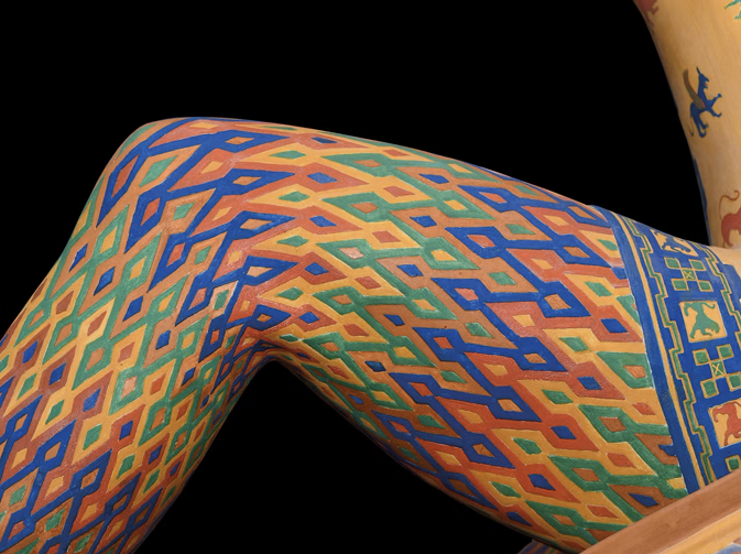 Leg of an ancient marble sculpture with an intricate zigzag pattern painted on it.