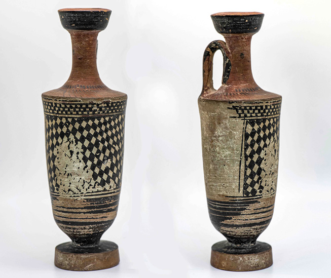 Ancient pottery vessel with a handle and a narrow neck showing a checker pattern.