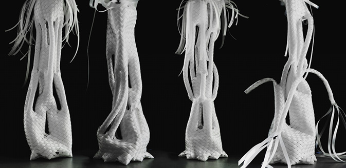 Four abstract, white braided structures stand on a dark background. Each has intricate textures and tendrils.