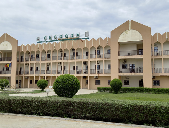 A three story peach-coloured building with green gardens is home to the medicines quality control laboratory.